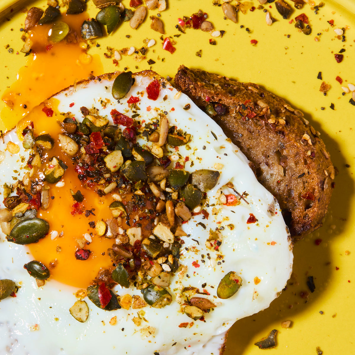 Fried egg with toast topped with punch your eggs spicy food topper on yellow plate