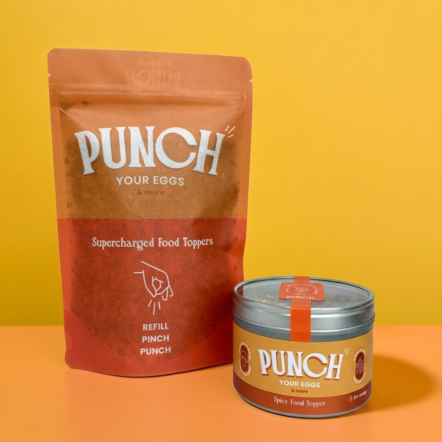 A pouch and a tin of PUNCH Your Eggs Supercharged Food Toppers on a two-toned yellow and orange background.