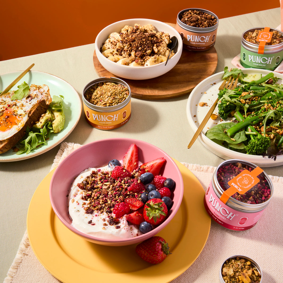 Table with various dishes including a bowl of yogurt with berries, a salad, and containers labeled 'Punch'.