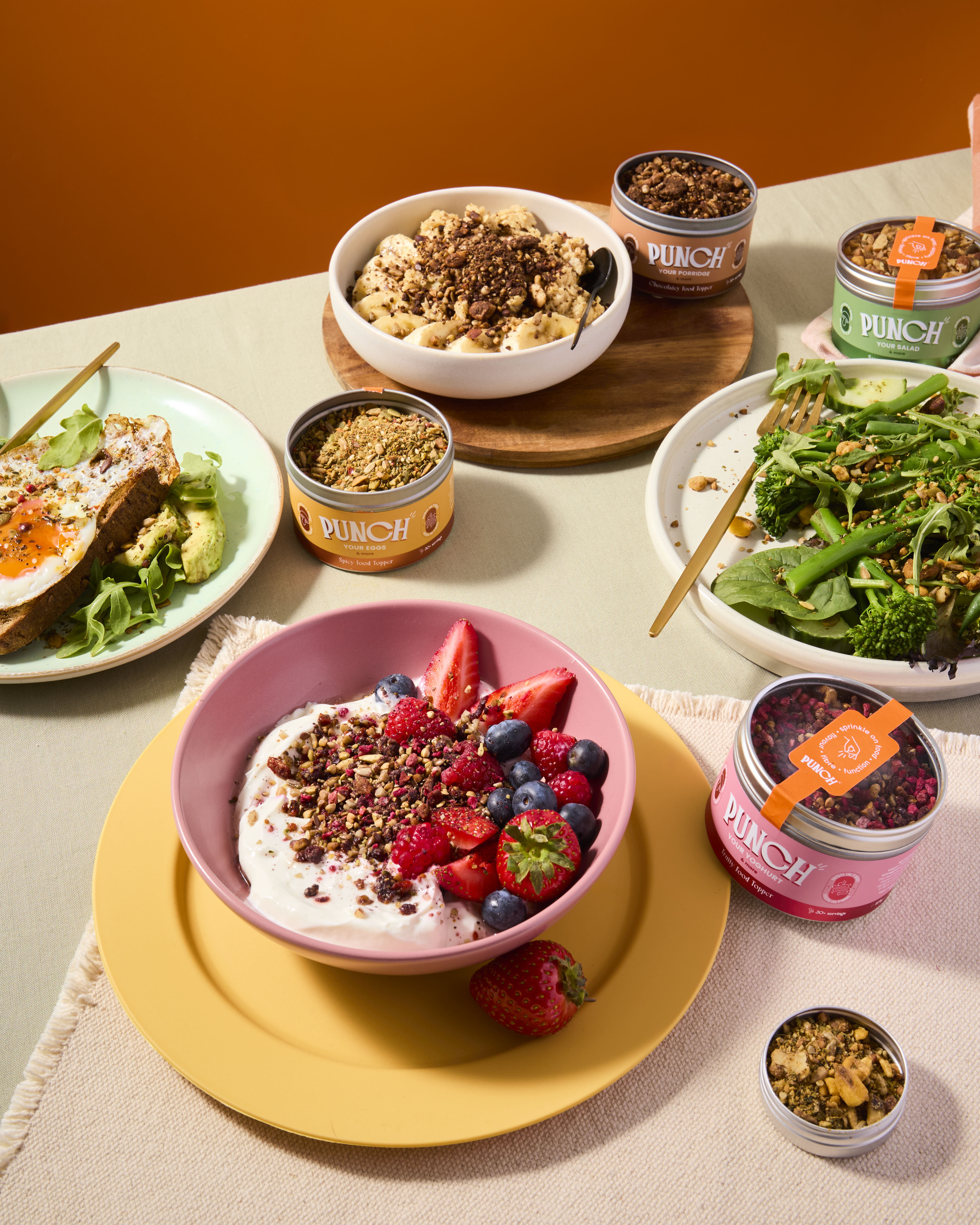 Table with various dishes including a bowl of yogurt with berries, a salad, and containers labeled 'Punch'.
