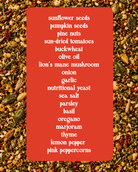 A red rectangular label with a white list of ingredients, including sunflower seeds, pumpkin seeds, pine nuts, sun-dried tomatoes, buckwheat, olive oil, lion's mane mushroom, onion, garlic, nutritional yeast, sea salt, parsley, basil, oregano, thyme, lemon pepper, and pink peppercorns, set against a close-up background of the same seed mixture.